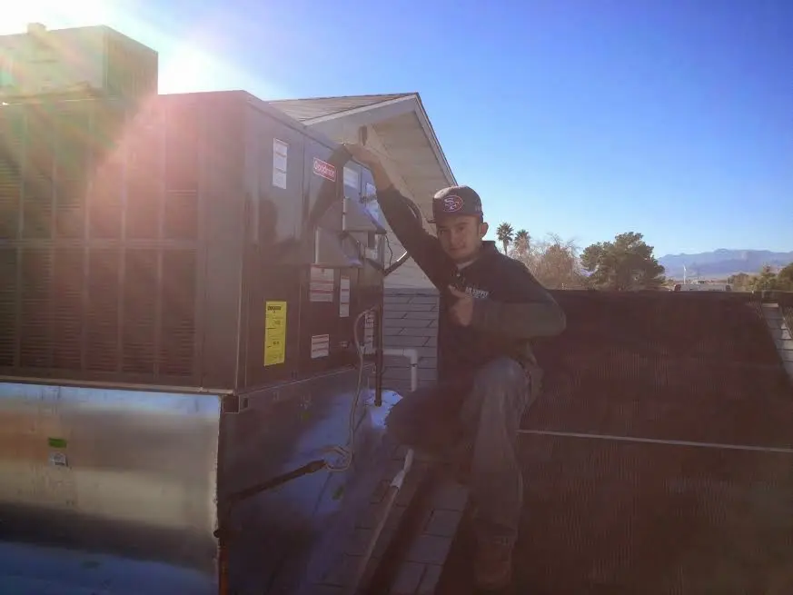 HVAC technician performing Boiler Repair on a rooftop unit in Pawling