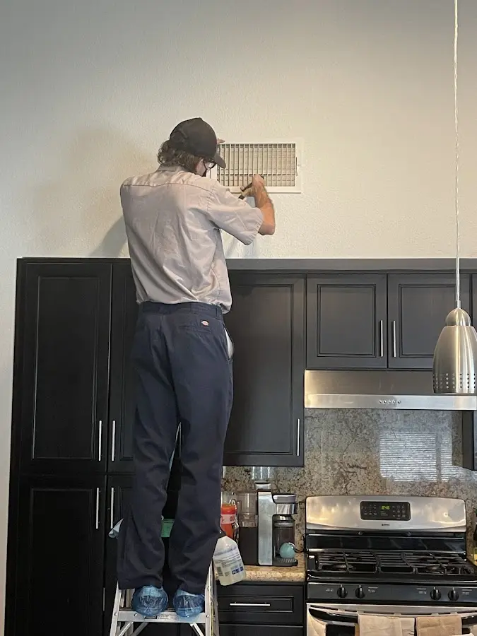 Technician inspecting an air vent during HVAC service in Pawling